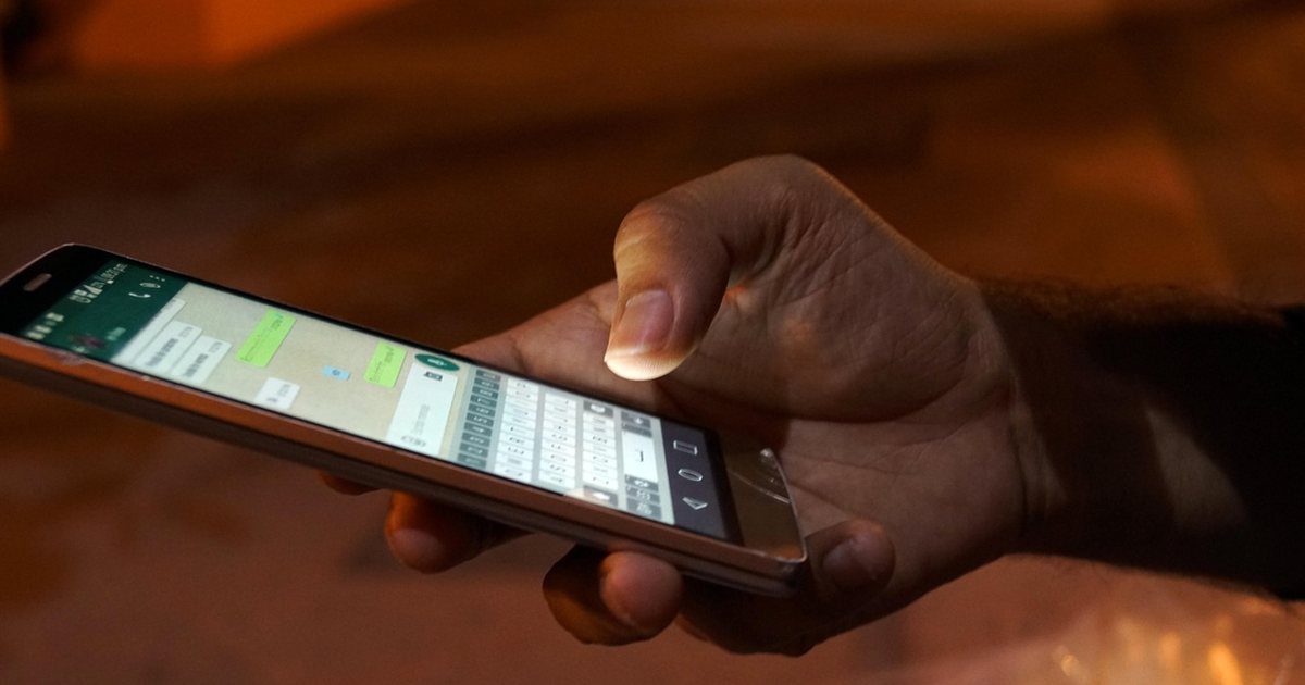 Person scrolling a smartphone in the dark